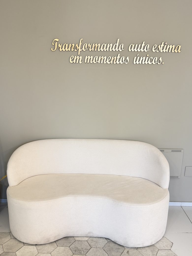 Recepção do consultório, com a frase “Transformando auto estima em momentos únicos” na parede